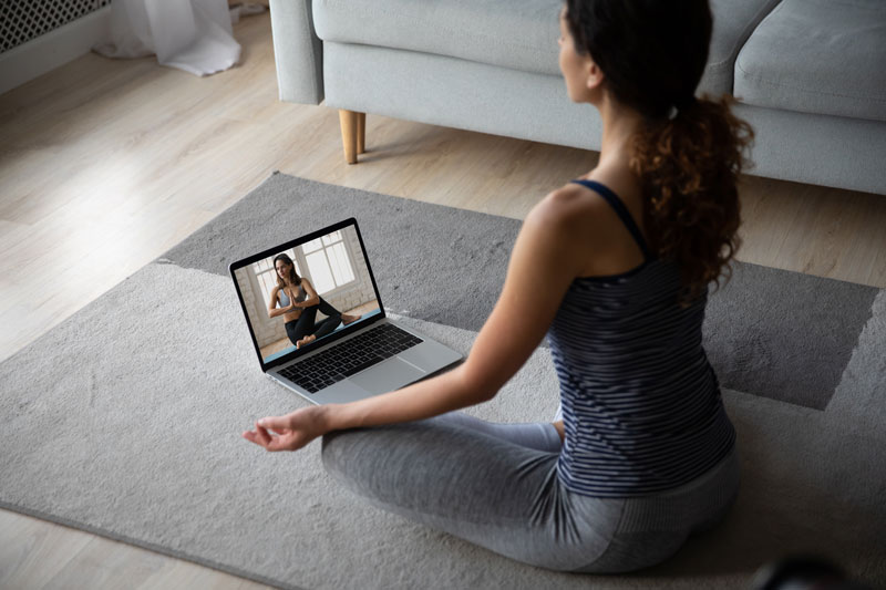 a woman sitting on the floor with a laptop